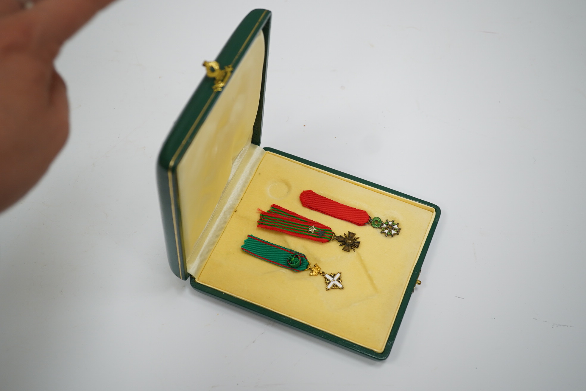 A framed medal group; Legion D'Honneur France, a British Cross, Italian order of Merit and Croix De Guerre with related book; La Legion d’Honneur by Jean Daniel, plus some related paperwork, three related medal miniature